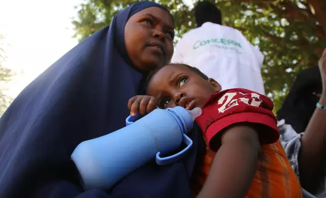A Somali woman displaced by drought sits holding her child at Feynuus Nutrition Centre on the outskirts of the capital, Mogadishu, Somalia, Wednesday, Aug. 19, 2026. (AP Photo/Farah Abdi Warsameh)