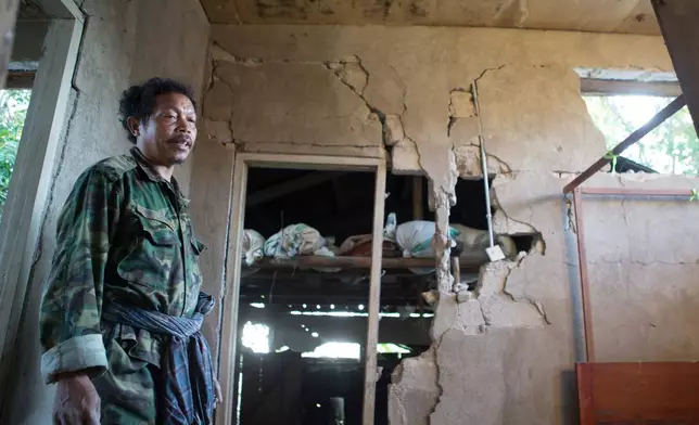 A man stands inside his earthquake-damaged house in Mbeliling, East Nusa Tenggara province, Indonesia, Sunday, Aug. 16, 2026. (AP Photo/Firdia Lisnawati)