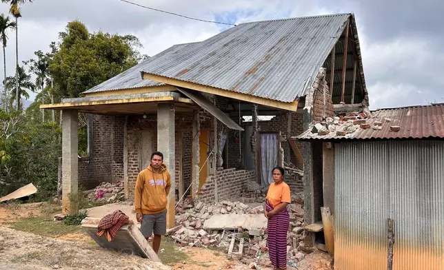 Maria Imakulata Ndue, right, and her son Yohanes Defrianus Ratu stand outside their earthquake-damaged house in Lembor, East Nusa Tenggara province, Indonesia, Sunday, Aug. 16, 2026. (AP Photo/Firdia Lisnawati)