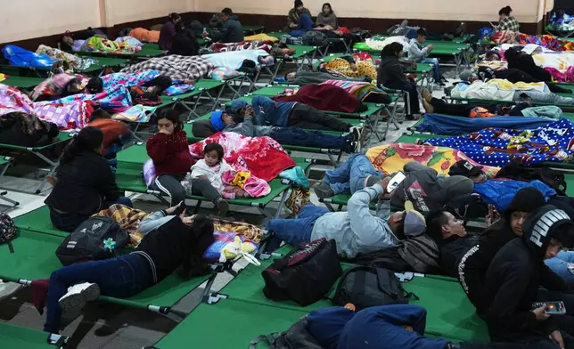 Families evacuated from areas surrounding the Fuego Volcano rest at a temporary shelter in San Juan Alotenango, Guatemala, Tuesday, Aug. 4, 2026. (AP Photo/Moises Castillo)