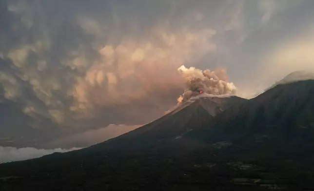 Lava flows and clouds of ash out of the crater of the Fuego Volcano, as seen from San Juan Alotenango, Guatemala, Tuesday, Aug. 4, 2026. (AP Photo/Moises Castillo)