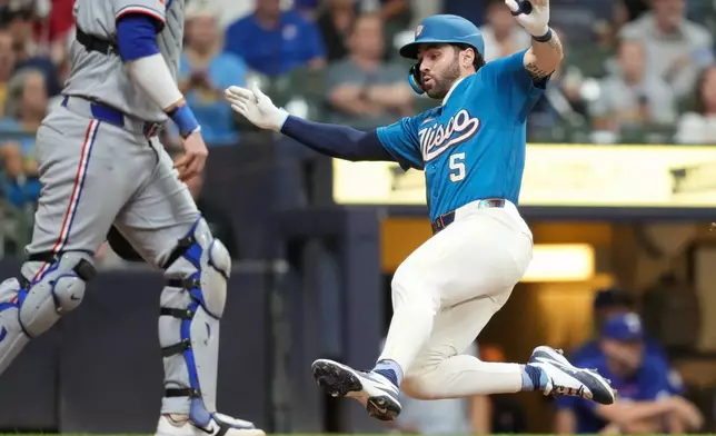 Milwaukee Brewers' Garrett Mitchell (5) scores on a single hit by David Hamilton during the sixth inning of a baseball game against the Texas Rangers Friday, Aug. 28, 2026, in Milwaukee. (AP Photo/Kayla Wolf)