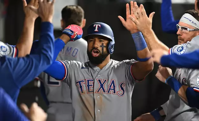 Texas Rangers' Ezequiel Duran, center, celebrates with teammates in the dugout after scoring on a wild pitch during the eighth inning of a baseball game against the Chicago White Sox in Chicago, Monday, Aug. 24, 2026. (AP Photo/Paul Beaty)