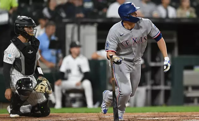 Texas Rangers' Corey Seager, right, watches his two-run double during the third inning of a baseball game against the Chicago White Sox in Chicago, Monday, Aug. 24, 2026. (AP Photo/Paul Beaty)