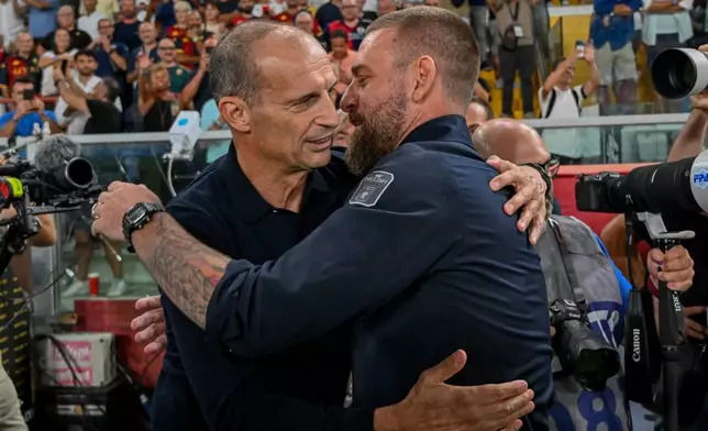 Genoa's head coach Daniele De Rossi, right, and Napoli's head coach Massimiliano Allegri embrace during the Serie A soccer match between Genoa and Napoli at the Luigi Ferraris Stadium in Genoa, Italy, Saturday, Aug. 22, 2026. (Tano Pecoraro/LaPresse via AP)