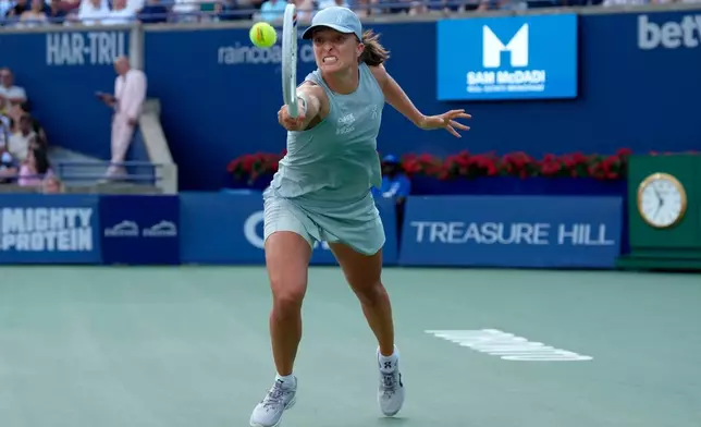 Poland's Iga Swiatek reaches for the return to Kazakhstan's Elena Rybakina during National Bank Open final tennis action, in Toronto, Thursday, Aug. 13, 2026. (Chris Young/The Canadian Press via AP)