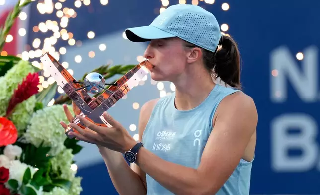 Poland's Iga Swiatek kisses the trophy after defeating Kazakhstan's Elena Rybakina in a National Bank Open final tennis match, in Toronto, Thursday, Aug. 13, 2026. (Chris Young/The Canadian Press via AP)