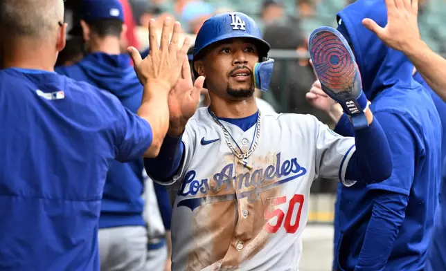 Los Angeles Dodgers' Mookie Betts (50) is congratulated in the dugout after scoring a run during the eighth inning of a baseball game against the Detroit Tigers, Sunday, Aug. 30, 2026, in Detroit. (AP Photo/Jose Juarez)