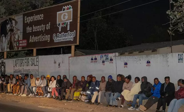 Zambians queue outside a polling station on the outskirts of Lusaka, Zambia, Thursday, Aug. 13, 2026. (AP Photo/Anita Reed)
