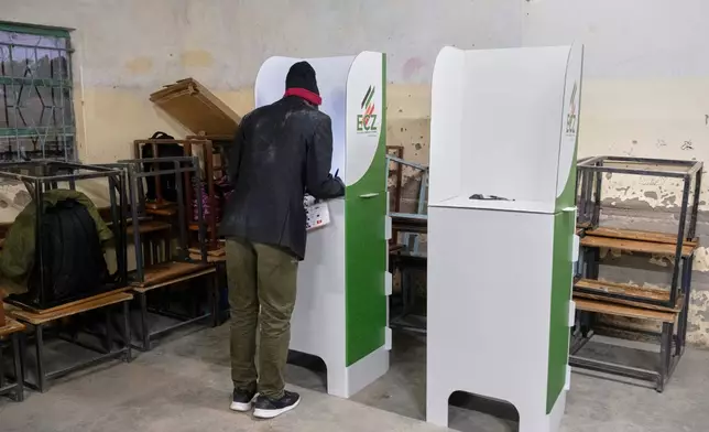 A man is seen in a voting booth at a polling station during a presidential election in Lusaka, Zambia, Thursday, Aug. 13, 2026. (AP Photo/Anita Reed)
