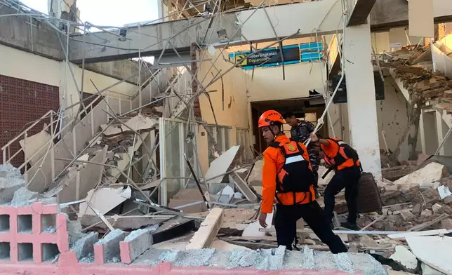 In this photo released by the Indonesian National Search and Rescue Agency (BASARNAS), rescuers search for victims at a damaged building following an earthquake in Maumere, East Nusa Tenggara Province, Indonesia, Saturday, Aug. 15, 2026. (BASARNAS via AP)