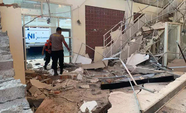 In this photo released by the Indonesian National Search and Rescue Agency (BASARNAS), rescuers inspect a damaged building following an earthquake in Maumere, East Nusa Tenggara Province, Indonesia, Saturday, Aug. 15, 2026. (BASARNAS via AP)