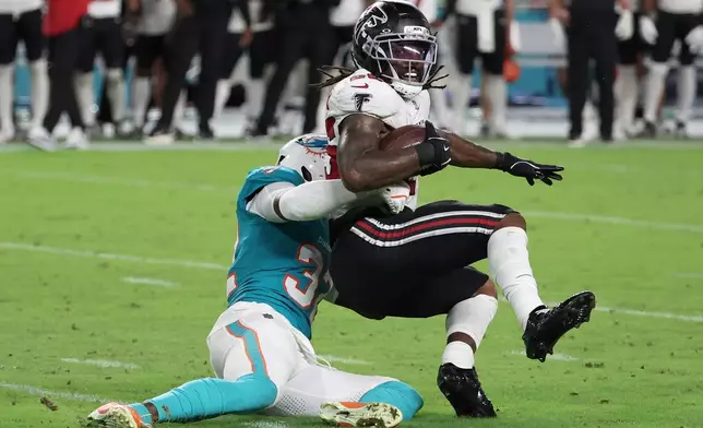 Atlanta Falcons running back Tyler Goodson, right, is tackled by Miami Dolphins defensive back Lonnie Johnson Jr. during the first half of an NFL preseason football game, Friday, Aug. 28, 2026, in Miami Gardens, Fla. (AP Photo/David Santiago)
