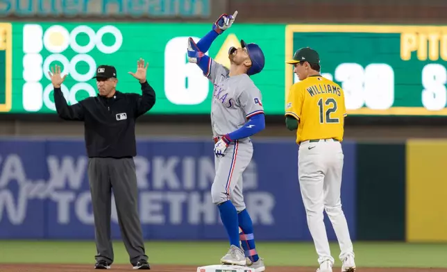 Texas Rangers' Brandon Nimmo, center, celebrates a double during the sixth inning of a baseball game against the Athletics Saturday, Aug. 15, 2026, in West Sacramento, Calif. (AP Photo/Sara Nevis)
