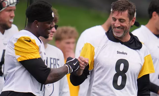 Pittsburgh Steelers quarterback Aaron Rodgers (8) fist bumps wide receiver Germie Bernard, left during the NFL team's training camp in Latrobe, Pa., Saturday, Aug. 1, 2026. (AP Photo/Gene J. Puskar)