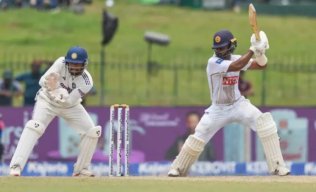 Sri Lanka's Pasindu Sooriyabandara plays a shot as India's Rishabh Pant watches during day three of the second cricket test match between Sri Lanka and India in Colombo, Sri Lanka, Tuesday, Aug. 25, 2026. (AP Photo/Eranga Jayawardena)