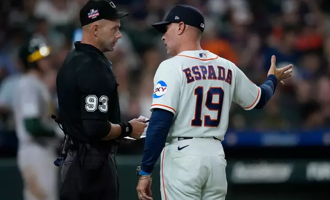 Home plate umpire Will Little (93) talks with Houston Astros manager Joe Espada (19) over a pitching change dispute during the sixth inning of a baseball game against the Athletics, Saturday, Aug. 22, 2026, in Houston. (AP Photo/Kevin M. Cox)