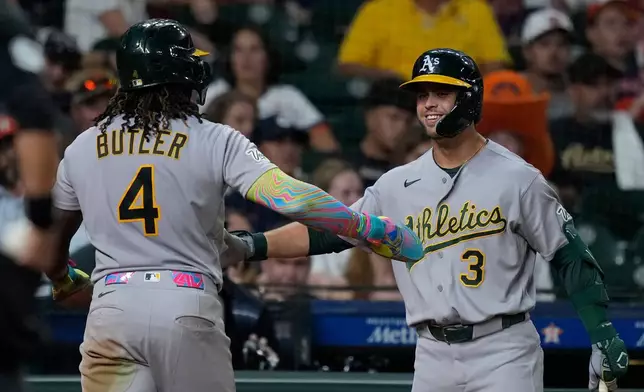 Athletics' Lawrence Butler (4) is congratulated by Max Muncy (3) after scoring during the eighth inning of a baseball game against the Houston Astros, Saturday, Aug. 22, 2026, in Houston. (AP Photo/Kevin M. Cox)