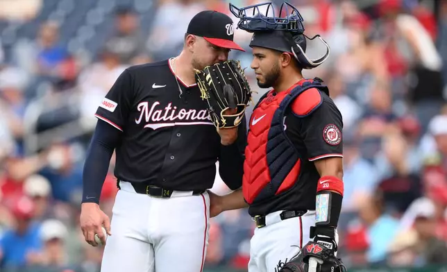 Washington Nationals pitcher Cade Cavalli, left, talks with catcher Keibert Ruiz, right, during the third inning of a baseball game, Thursday, Aug. 13, 2026, in Washington. (AP Photo/Nick Wass)