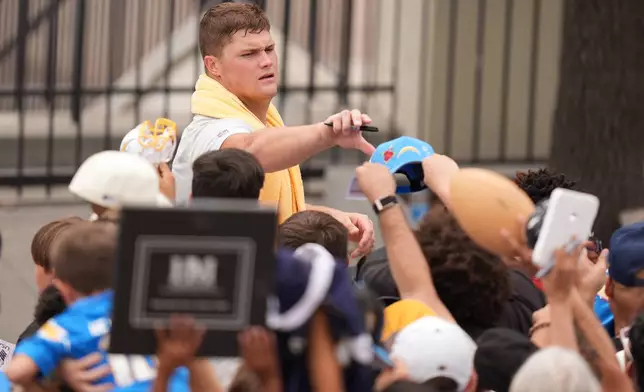 Los Angeles Chargers offensive tackle Joe Alt signs autographs during an NFL football training camp Wednesday, Aug. 5, 2026, in San Diego. (AP Photo/Gregory Bull)
