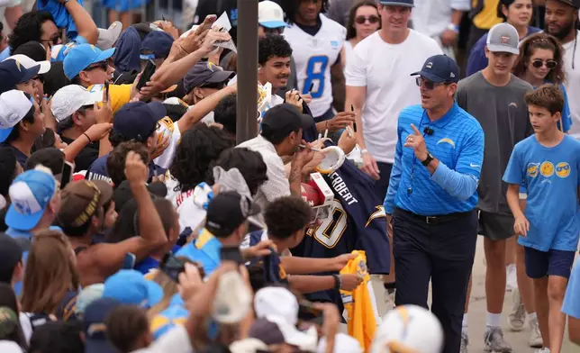 Los Angeles Chargers head coach Jim Harbaugh greets fans during an NFL football training camp Wednesday, Aug. 5, 2026, in San Diego. (AP Photo/Gregory Bull)