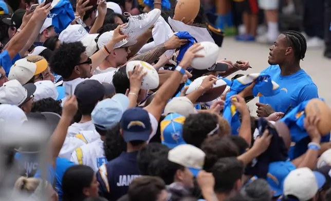 Los Angeles Chargers safety Derwin James Jr. signs autographs during an NFL football training camp Wednesday, Aug. 5, 2026, in San Diego. (AP Photo/Gregory Bull)