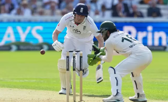 England's Dan Lawrence fails to make his crease as Pakistan's Mohammad Rizwan, right, prepares to collect the ball to run him out during the second cricket test match between England and Pakistan in London, Thursday, Aug. 27, 2026. (AP Photo/Dave Shopland)