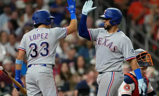 Texas Rangers' Elias Díaz, right, celebrates with Nicky Lopez (33) after hitting a home run against the Houston Astros during the sixth inning of a baseball game Saturday, Aug. 1, 2026, in Houston. (AP Photo/David J. Phillip)