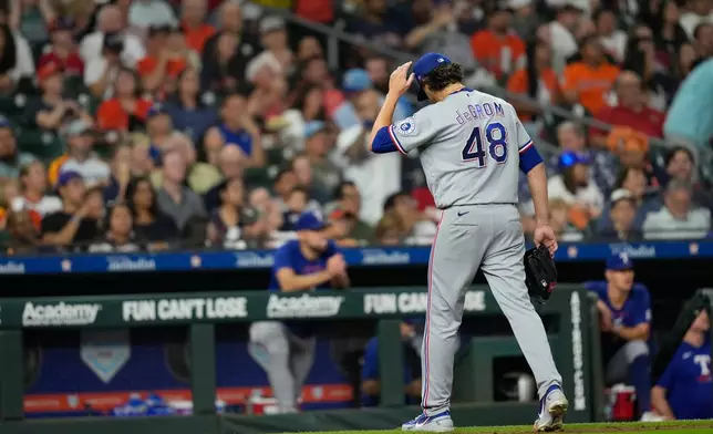Texas Rangers starting pitcher Jacob Degrom walks toward the dugout after being pulled during the fourth inning of a baseball game against the Houston Astros Saturday, Aug. 1, 2026, in Houston. (AP Photo/David J. Phillip)