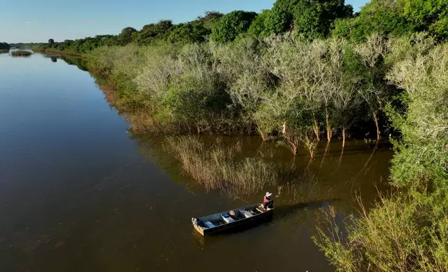 FILE - A woman from the Java Indigenous group fishes in the Javae River on Bananal Island in Formoso do Araguaia, Tocantins state, Brazil, May 20, 2026. (AP Photo/Andre Penner, File)