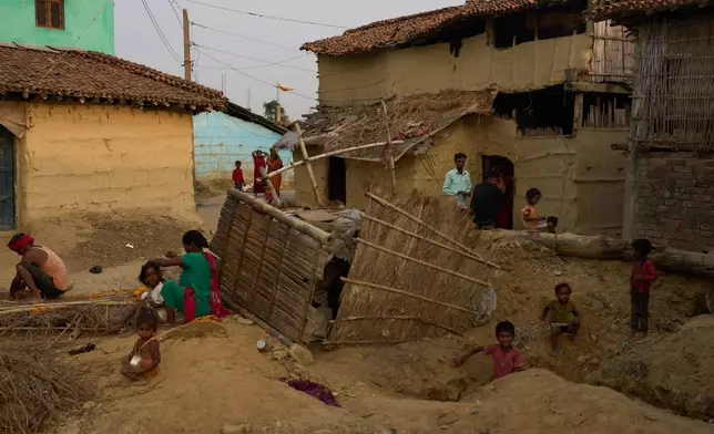 Residents sit outside their homes in Gaur, Nepal, on May 19, 2026. (AP Photo/Bram Janssen)