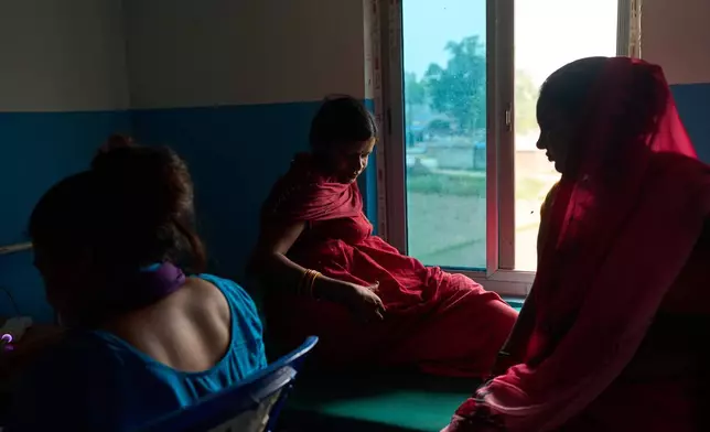Nitu Devi, 22, who is pregnant, sits on a bed before an ultrasound inside a clinic in Gaur, Nepal, on May 20, 2026. (AP Photo/Bram Janssen)