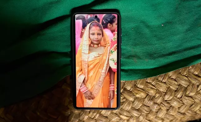 A photo of Kabita Mukhiya, who died during pregnancy, is displayed on a phone on May 19, 2026, in Gaur, Nepal. (AP Photo/Bram Janssen)