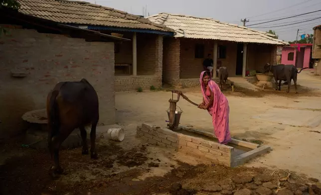 A woman collects water from a well in Gaur, Nepal, on May 19, 2026. (AP Photo/Bram Janssen)