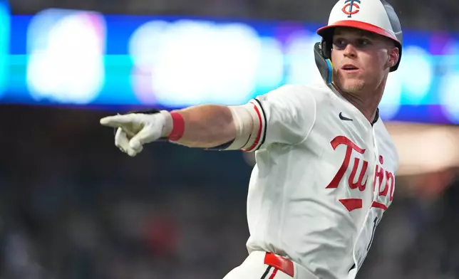 Minnesota Twins' Walker Jenkins points to the bench after hitting a single, making his MLB debut, during the fourth inning of a baseball game against the Chicago White Sox, Friday, Aug. 28, 2026, in Minneapolis. (AP Photo/Ellen Schmidt)