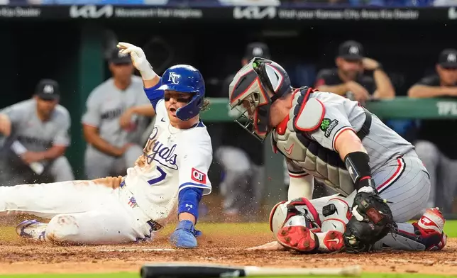 Kansas City Royals' Bobby Witt Jr. (7) beats the tag by Minnesota Twins catcher Ryan Jeffers to score on a fielder's choice hit into by Jac Caglianone during the fifth inning of a baseball game Tuesday, Aug. 4, 2026, in Kansas City, Mo. (AP Photo/Charlie Riedel)