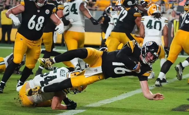 Pittsburgh Steelers quarterback Drew Allar (16) divers over Green Bay Packers linebacker Kristian Welch into the end zone for a touchdown in the second half of a preseason NFL football game in Pittsburgh, Thursday, Aug. 13, 2026. (AP Photo/Gene J. Puskar)