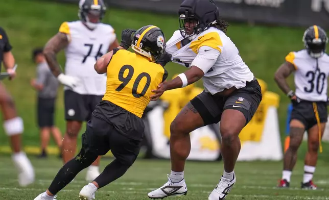 Pittsburgh Steelers offensive tackle Max Iheanachor, right, attempts to block linebacker T.J. Watt (90) during the NFL team's camp in Latrobe, Pa., Saturday, Aug. 1, 2026. (AP Photo/Gene J. Puskar)