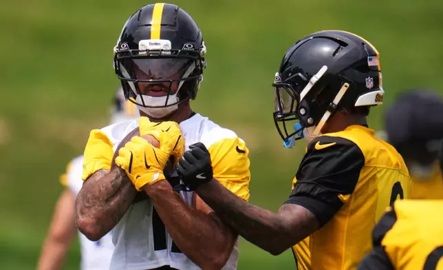 Pittsburgh Steelers safety Jaquan Brisker, right, attempt to punch the ball from the grasp of wide receiver Michael Pittman Jr., during the NFL team's camp in Latrobe, Pa., Saturday, Aug. 1, 2026. (AP Photo/Gene J. Puskar)
