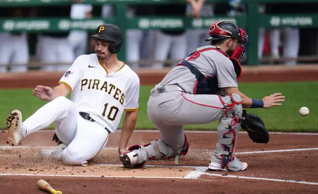 Pittsburgh Pirates' Bryan Reynolds (10) scores ahead of a throw to Boston Red Sox catcher Connor Wong, right, on a single by Brandon Lowe off Red Sox pitcher Patrick Sandoval during the first inning of a baseball game in Pittsburgh, Sunday, Aug. 16, 2026. (AP Photo/Gene J. Puskar)