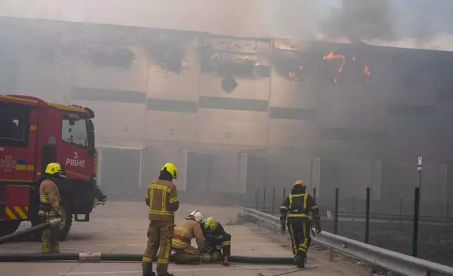 Firefighters put out a fire at warehouse stores after a Russian air attack in Kyiv, Ukraine, Thursday, Aug. 27, 2026. (AP Photo/Efrem Lukatsky)
