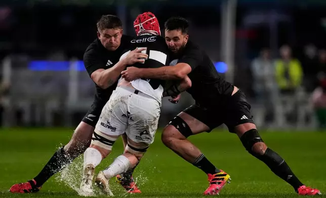 All Blacks' Ethan de Groot, left, with his teammate Josh Lord, right, tackle Sharks' Hendrè Stassen, during a friendly rugby match between Sharks and All Blacks, in Durban, Tuesday, Aug. 11, 2026. (AP Photo/Themba Hadebe)