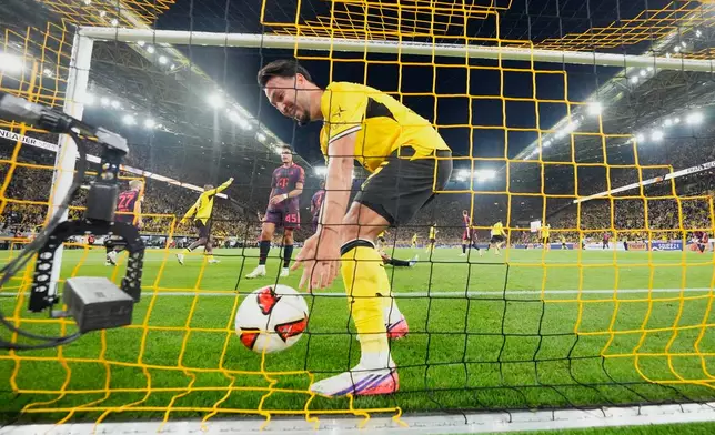 Dortmund's Ramy Bensebaini takes the ball after scoring a goal that was disallowed for offside during the Franz Beckenbauer German Supercup soccer match between Borussia Dortmund and Bayern Munich in Dortmund, Germany, Saturday, Aug. 22, 2026. (AP Photo/Martin Meissner)