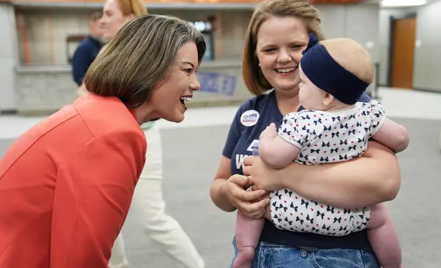 U.S. Rep. Angie Craig, D-Minn., candidate for U.S Senate, greets Merci Wolff and her daughter during a canvassing event at SMART Sheet Metal Workers Local #10 headquarters, Monday, Aug. 10, 2026, in St. Paul, Minn. (AP Photo/Ellen Schmidt)