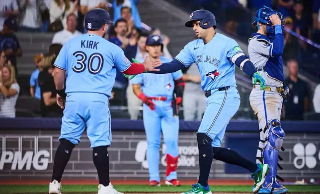Toronto Blue Jays' George Springer (4), right, celebrates with Alejandro Kirk (30) after hitting a two-run home run against the Kansas City Royals during sixth inning of a baseball game in Toronto, Thursday, Aug. 27, 2026. (Sammy Kogan/The Canadian Press via AP)