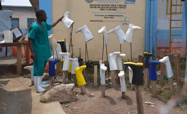 A health worker dries boots that were washed to prevent the spread of the Ebola virus at the treatment centre in Bunia General Hospital in Ituri, eastern Congo, Tuesday, Aug. 11, 2026. (AP Photo/Dieudonne Dirole)