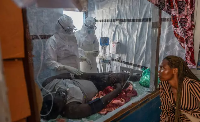 Health workers tend to an Ebola patient at the Rwampara Treatment Center in Ituri, Congo, Thursday, June 18, 2026. (AP Photo/Moses Sawasawa)