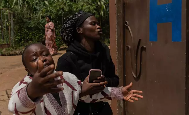 Relatives of Angèle Muyumba Nsimire, a university student who died of Ebola, react at the Citadelle Clinic as health workers prepare her body for burial in Bunia, Congo, Friday, June 12, 2026. (AP Photo/Moses Sawasawa)