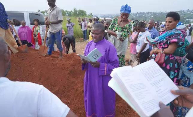A priest leads a burial service for Jeannine Katusabe, who died of Ebola, in Bunia, Ituri province, eastern Congo, Tuesday, Aug. 11, 2026. (AP Photo/Dieudonne Dirole)