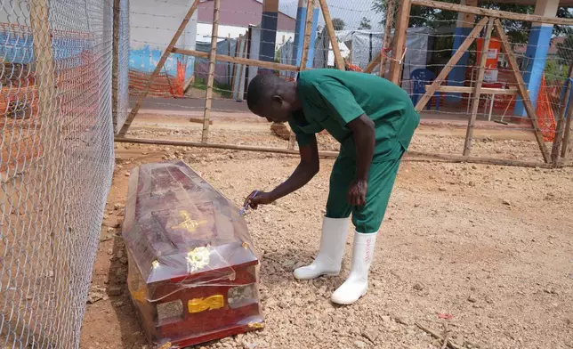 A health worker on the dignified and safe burial team, monitors a casket at the treatment centre in Bunia General Hospital in Ituri, eastern Congo, Tuesday, Aug. 11, 2026. (AP Photo/Dieudonne Dirole)